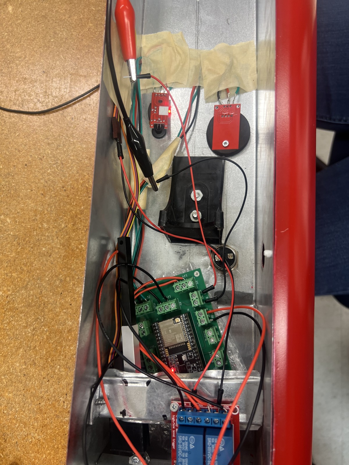 IoT prototype showing the ESP32 circuit board, sensors, wiring, and relays inside the enclosure